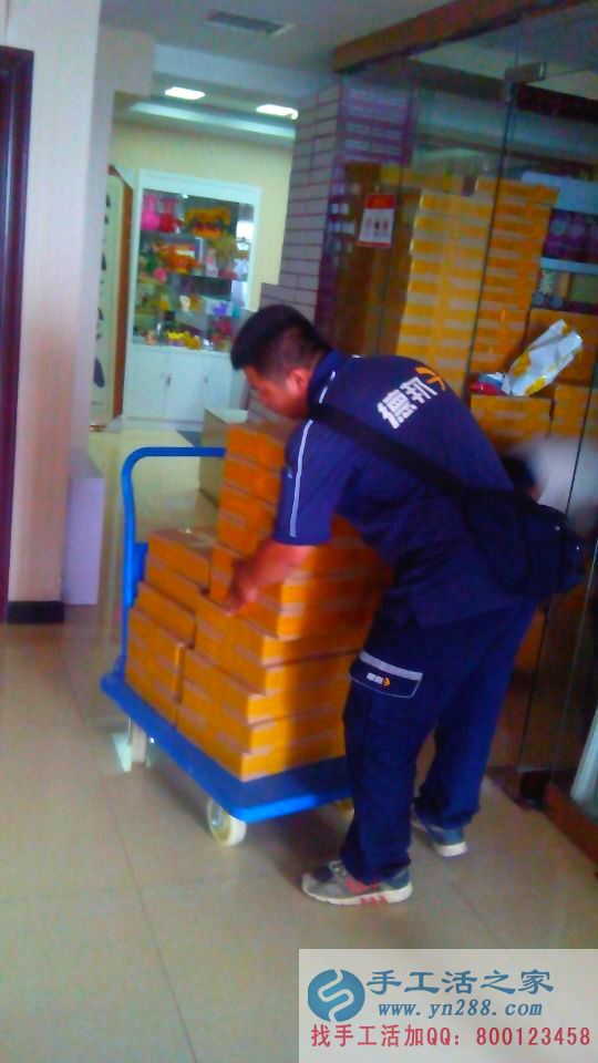 德邦人員從存貨間出來，正在放快遞盒